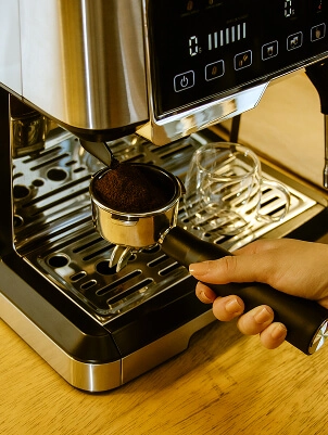 Imagem de pessoa colocando o café moído na cafeteira
